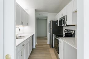 Chicago apartment for rent - A kitchen with white cabinets and black appliances at Columbus Plaza, Chicago, 60601