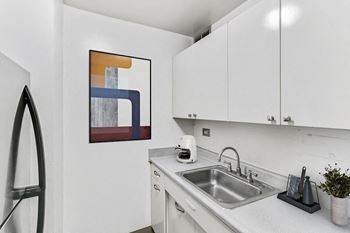 A kitchen with white cabinetry and a sink