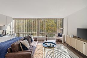 Detroit apartment for rent - a bedroom with a bed and a couch and a tv at The Pavilion, Detroit, 48207