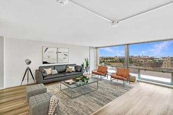 A living room with a large window and a view of a city