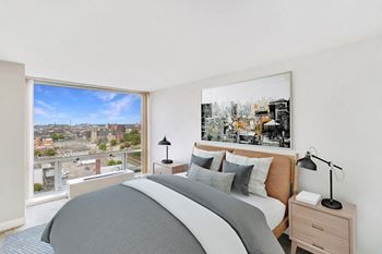 A bedroom with a bed and a large window
