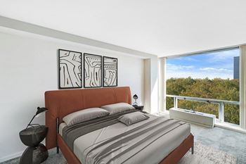 A bedroom with a bed and a large window