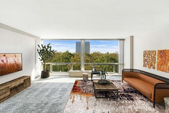 A living room with a large window and a view of the city