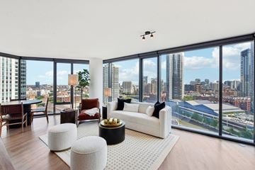 Chicago apartment for rent - a living room with a view of the city and a white couch and a table