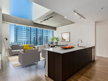 Chicago apartment for rent - A modern kitchen with a large island and a living area with a couch and a chair.