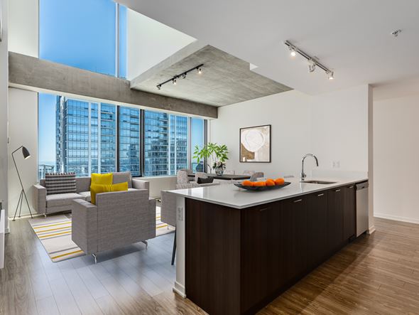Chicago apartment for rent - A modern kitchen with a large island and a living area with a couch and a chair.