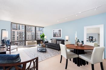 A living and dining room area with blue walls and a large window