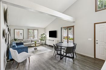A living room with a blue couch and a white chair.