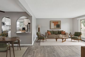 Eagan apartment for rent - A living room with a grey couch, a wooden coffee table, and a painting on the wall.