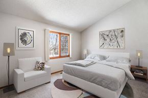 Woodbury townhouse for rent - a bedroom with a bed and a chair and a window at Seasons Villas, Woodbury, MN