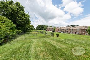 Johnson City townhouse for rent - A fenced in dog park with apartment buildings in the background.