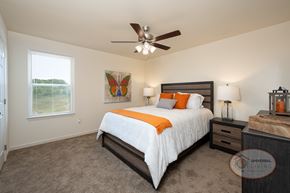 Sevierville townhouse for rent - A bedroom with a bed, nightstand, and a ceiling fan.