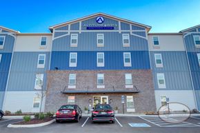 Knoxville apartment for rent - The front of a blue and grey apartment building with stone accents and a sign that reads "Altitude @ 6313."