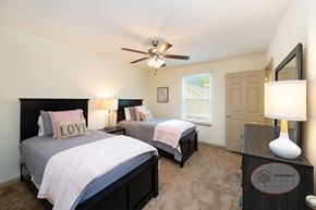 Arden townhouse for rent - A bedroom with two beds, a ceiling fan, and carpet.