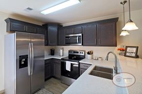 Arden townhouse for rent - A kitchen with dark cabinets and stainless steel appliances.