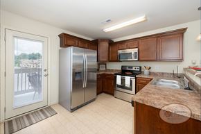 Johnson City townhouse for rent - A kitchen with stainless steel refrigerator, microwave, oven, sink and cabinets.