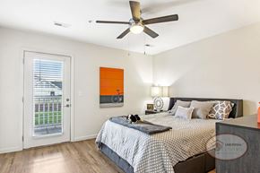 Knoxville townhouse for rent - A bedroom with a bed, a ceiling fan, and a window with blinds.