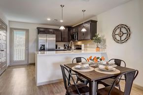 Powell townhouse for rent - A kitchen with hardwood vinyl flooring, white walls, dark cabinets, and stainless steel appliances.