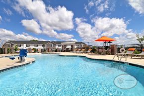 Powell townhouse for rent - A swimming pool with a blue sky and a row of grey and white apartment buildings in the background.
