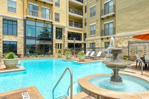 San Antonio apartment for rent - a swimming pool with a fountain in front of an apartment building