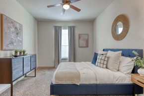 San Antonio apartment for rent - a bedroom with a large bed and a ceiling fan