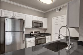 Sacramento apartment for rent - A kitchen with a stainless steel refrigerator and a black countertop.