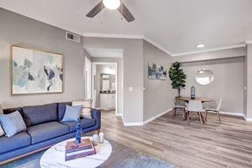 Sacramento apartment for rent - A living room with a blue couch and a painting on the wall.