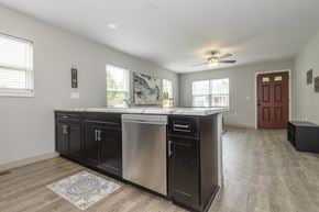 Milwaukee triplex for rent - A kitchen with a stainless steel dishwasher and black cabinets.
