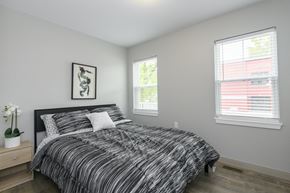 Milwaukee triplex for rent - A bedroom with a large bed and a framed picture on the wall.