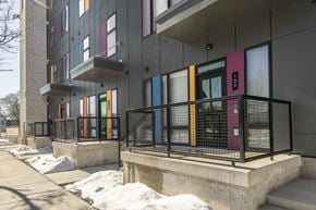 Milwaukee apartment for rent - A building with a black fence and colorful doors.
