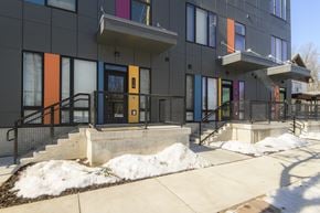 Milwaukee apartment for rent - A modern building with a black facade and colorful doors.