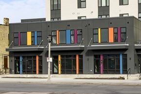 Milwaukee apartment for rent - A building with a grey facade has a row of windows with brightly colored panels on them.