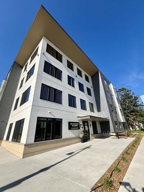 La Crosse apartment for rent - A modern building with a white facade and a yellow roof.