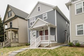 Milwaukee triplex for rent - A house with a grey and white exterior and a red door.