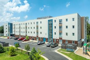Madison apartment for rent - A large white building with a parking lot in front.