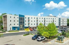 Madison apartment for rent - A parking lot in front of a large building with a blue and white sign.