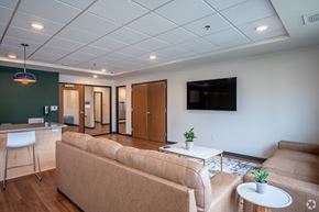 La Crosse apartment for rent - A living room with a couch, a chair, a table, and a television.