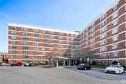 Arlington apartment for rent - A large red brick building with a parking lot in front.