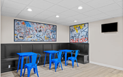 Arlington apartment for rent - A room with blue chairs and tables and two paintings on the wall.