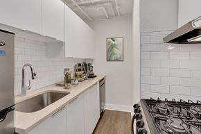 Denver apartment for rent - A kitchen with white cabinets and a stainless steel refrigerator.
