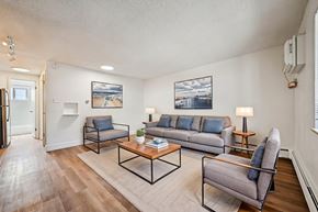 Denver apartment for rent - A living room with a grey couch, a black chair, and a coffee table.