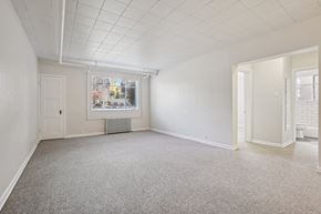 Denver apartment for rent - A spacious room with a carpeted floor and white walls.