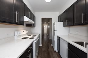 Glendale apartment for rent - a kitchen with white countertops and black cabinets and white appliances