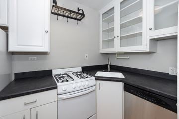 Denver apartment for rent - a kitchen with white appliances and black counter tops and white cabinets