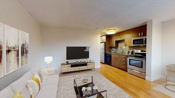 Denver apartment for rent - A modern living room with a white sofa and a television.