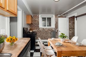 Denver apartment for rent - A kitchen with a wooden table and chairs with a vase of flowers on it.