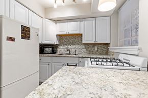 Denver apartment for rent - a kitchen with white cabinets and granite countertops