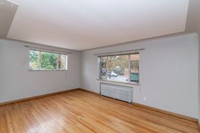 Denver apartment for rent - A room with wooden floors and two windows.