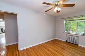 Denver apartment for rent - A room with a ceiling fan and a window with a view of trees.
