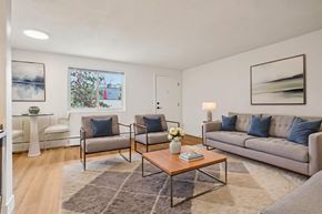 Denver apartment for rent - A living room with a grey couch, a coffee table, and a rug.